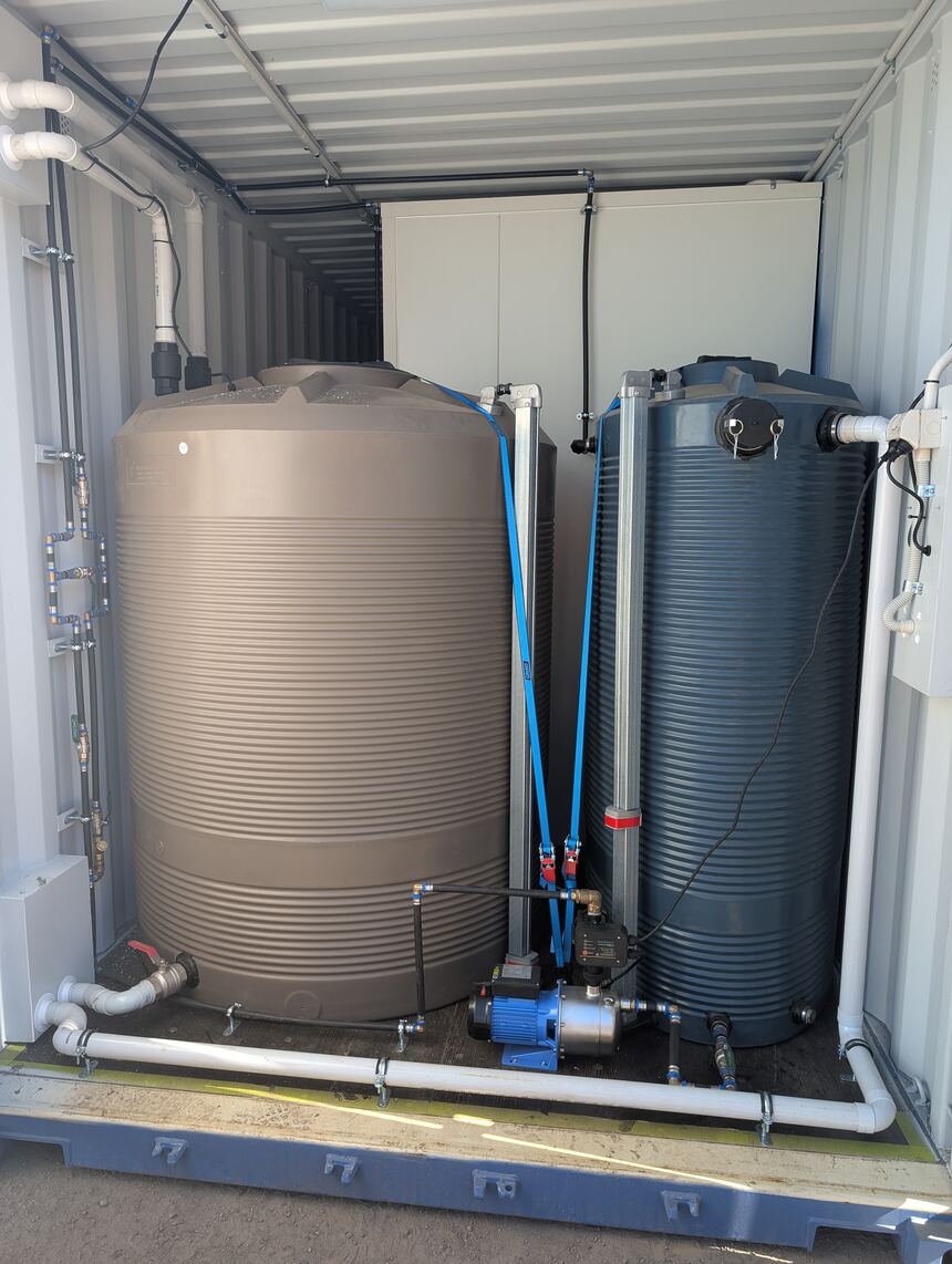 Water tanks and pump plumbed into a container to service a self-contained ablution block